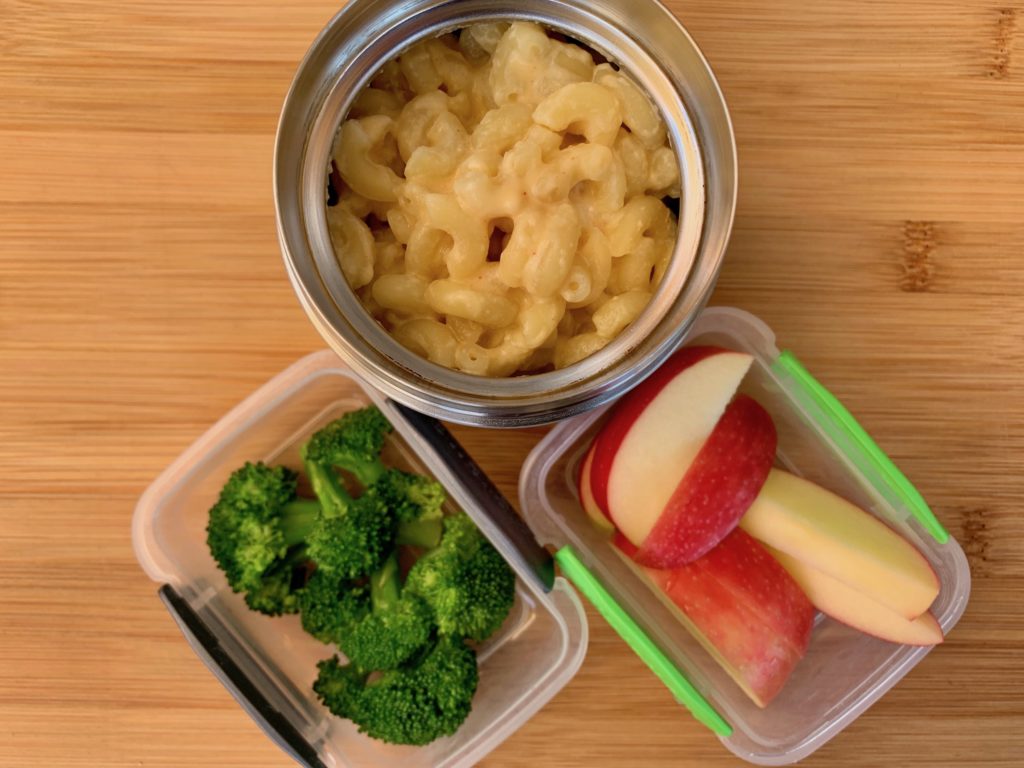 Hot lunch macaroni and cheese with broccoli and apple slices